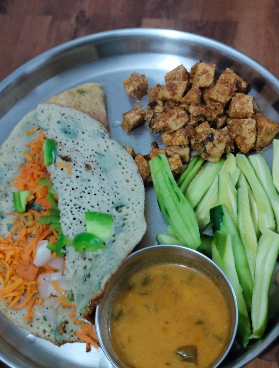 One of Raagini's everyday plates: an oats and vegetable adai, paneer, sambar, and raw cucumber and carrot